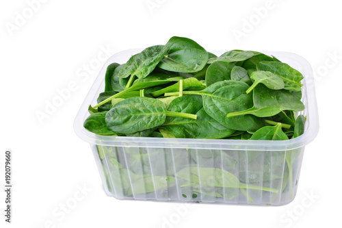 Baby spinach leaves in plastic container isolated on white background