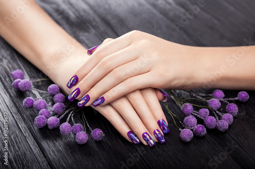 Shattered glass purple manicure on black background photo