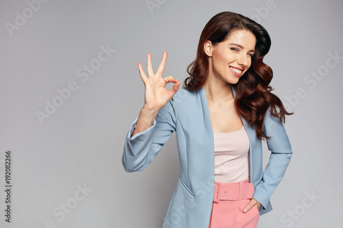 fashionable smiling woman showing okay
