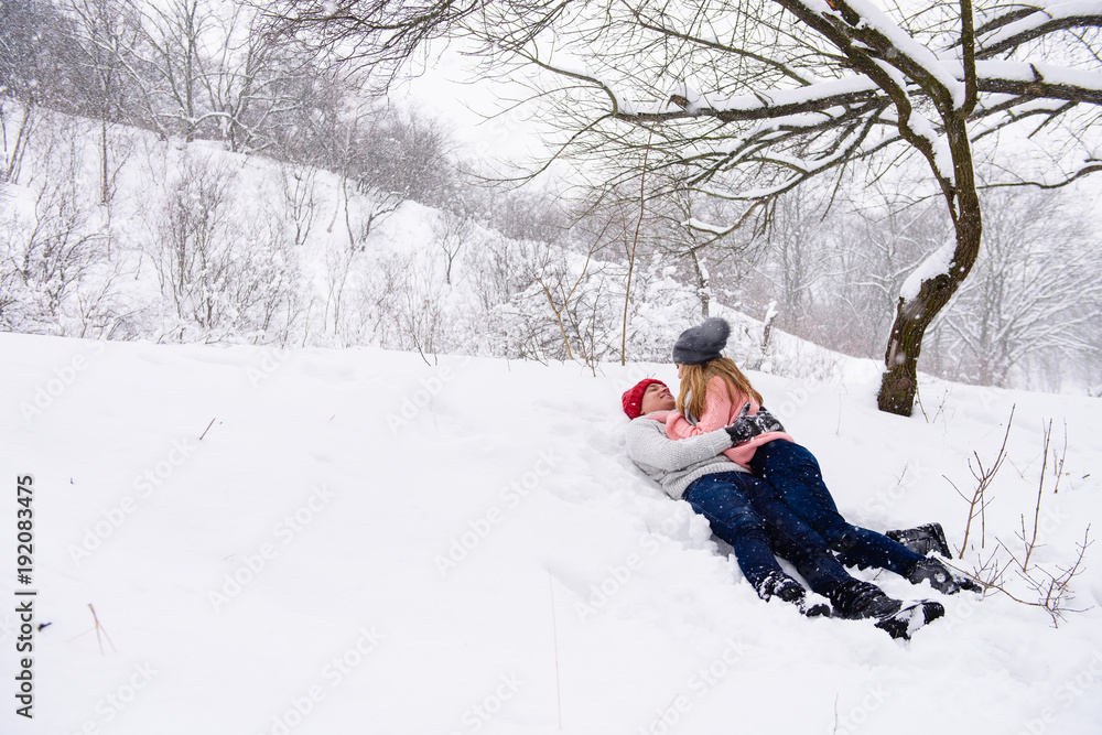 Winter landscape with a couple laying in snow