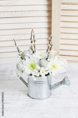 Floral arrangement inside silver watering can. © agneskantaruk