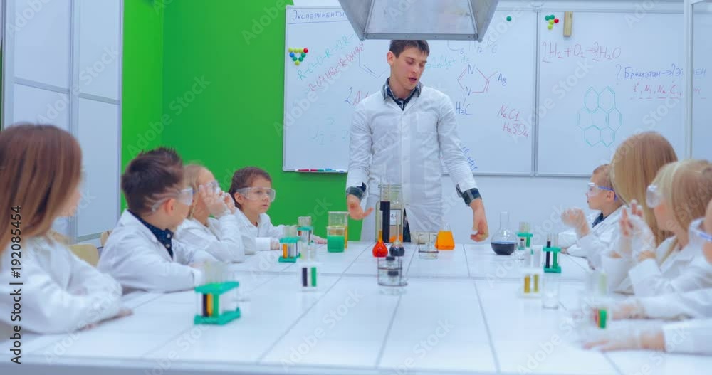 Teacher explaining an experiment to a high school chemistry class together Teacher explaining an experiment to a high school chemistry class together