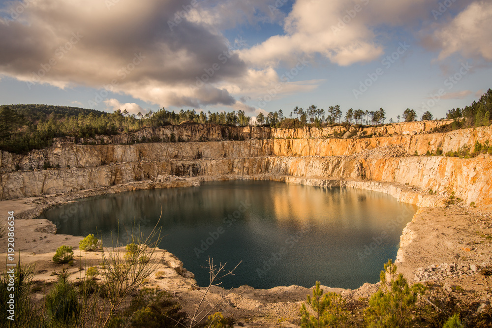 Blue lake in mining industrial crater, acid mine drainage in rock
