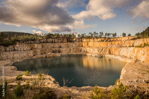 Blue lake in mining industrial crater, acid mine drainage in rock