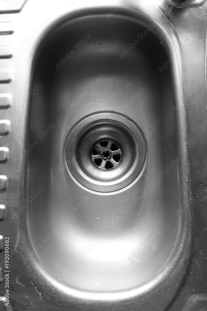 Dirty and scratched domestic kitchen sink and plug hole in black and white Dirty and scratched domestic kitchen sink and plug hole in black and white