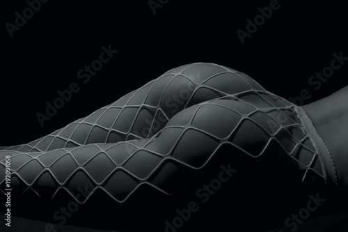 Silhouette of a body part , nude woman with fishnets on black background photo