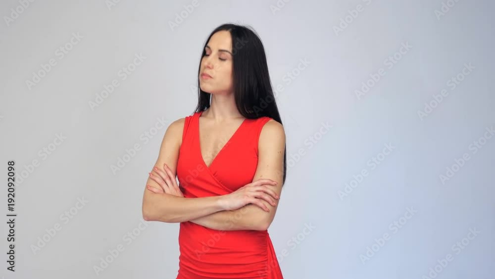 Upset woman in red red dress looking downwards while waiting for someone Upset woman in red red dress looking downwards while waiting for someone