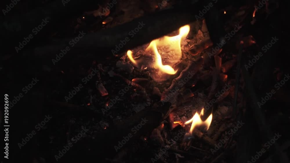 Firewood crackling blazing orange flame in pile of campfire lots of ashes and sparks, slow motion close up shot Firewood crackling blazing orange flame in pile of campfire lots of ashes and sparks, slow motion close up shot