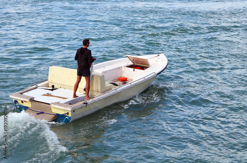Fotografija Open fishing boat being guided across the florida intra-coastal waterway by a single helmsman