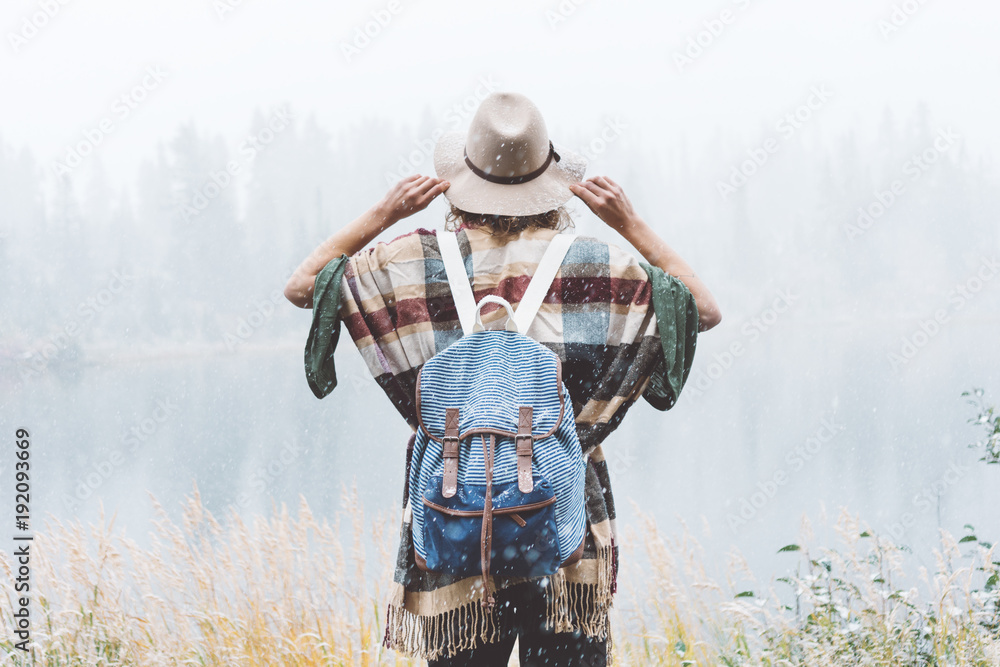 Travel woman feeling happy among amazing mountains, enjoy the nature landsape. Forest and lake, wearing backpack, hat and poncho, boho and wanderlust style Travel woman feeling happy among amazing mountains, enjoy the nature landsape. Forest and lake, wearing backpack, hat and poncho, boho and wanderlust style