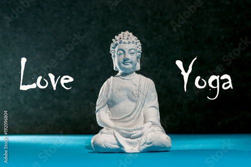 Love Yoga. Figurine of Buddha. Meditating Buddha statue like sumbol of yoga, zen and healthy life photo