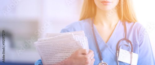 Doctor woman is standing in the near window photo