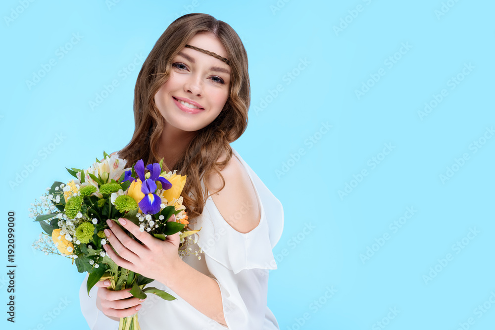 happy young woman holding floral bouquet isolated on blue happy young woman holding floral bouquet isolated on blue