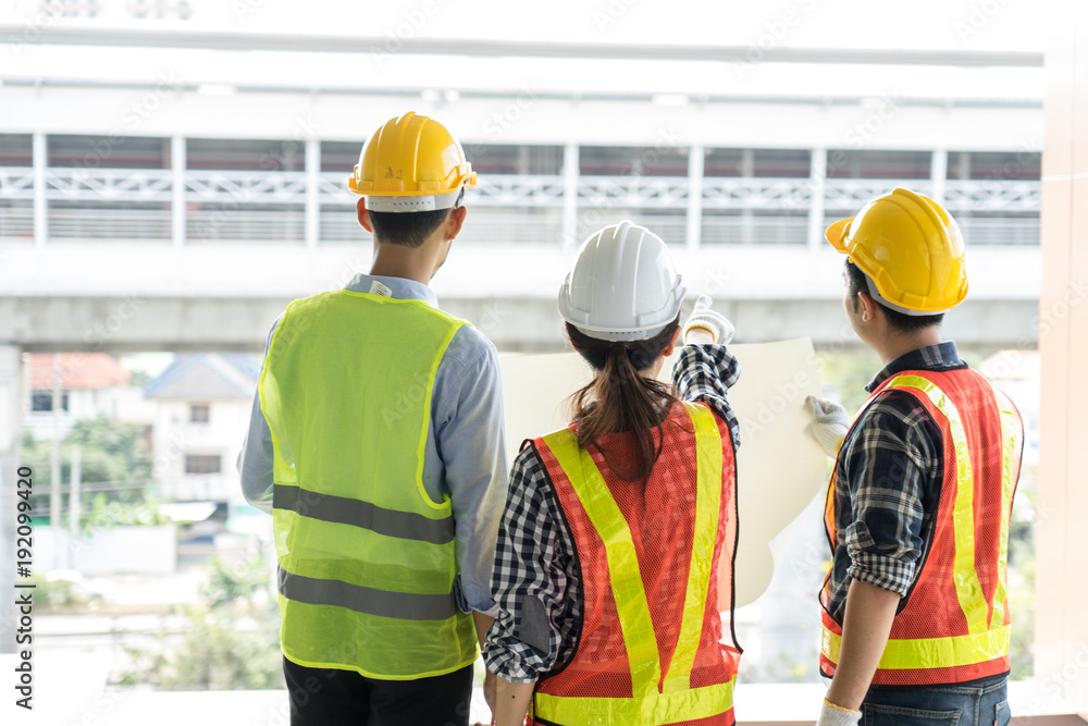 engineers visit the construction site.Examining blueprint with construction manager. engineers visit the construction site.Examining blueprint with construction manager.