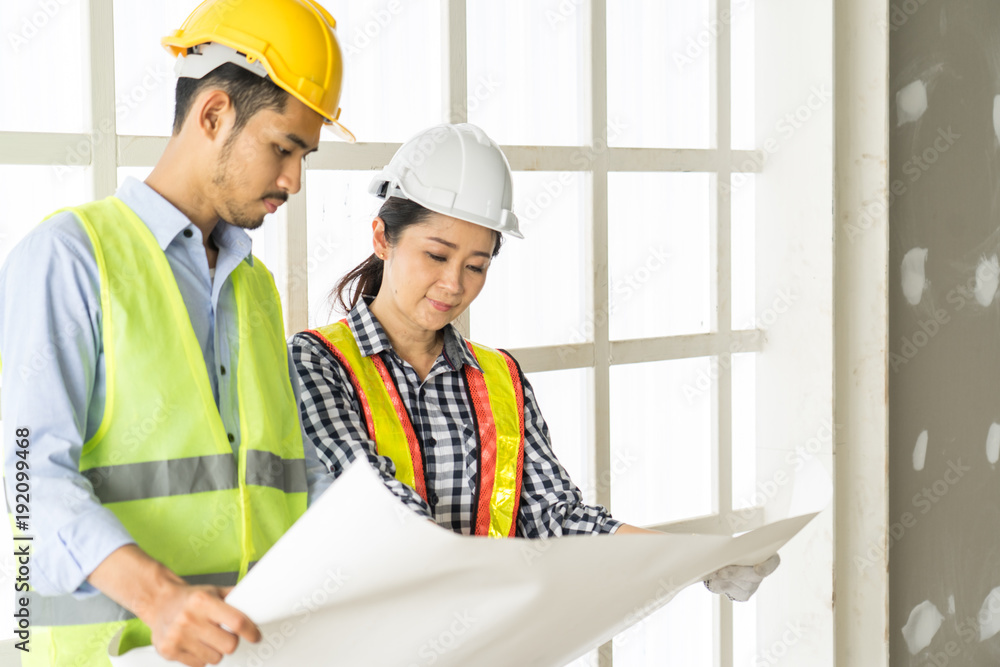 engineers visit the construction site.Examining blueprint with construction manager. engineers visit the construction site.Examining blueprint with construction manager.