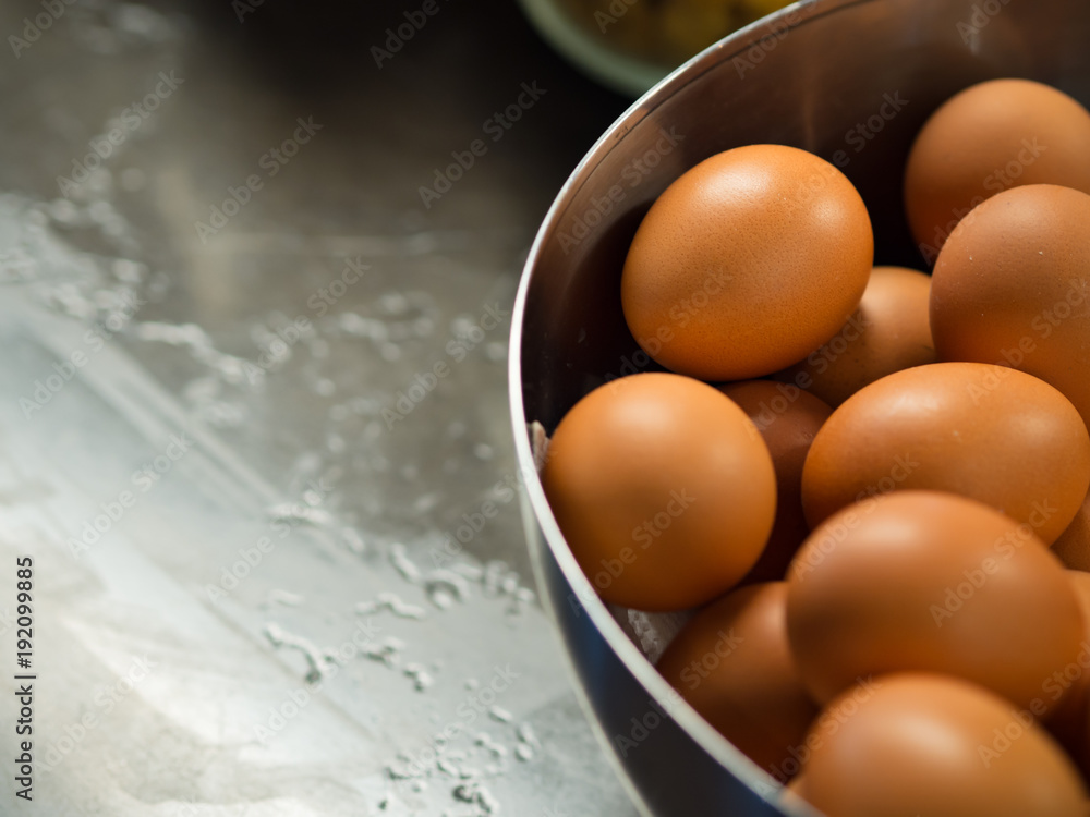 Dozen of chicken eggs, yolk and egg white, in a cooking bowl on kitchen table prepared for cooking or baking pastry in kitchen room or pantry Dozen of chicken eggs, yolk and egg white, in a cooking bowl on kitchen table prepared for cooking or baking pastry in kitchen room or pantry