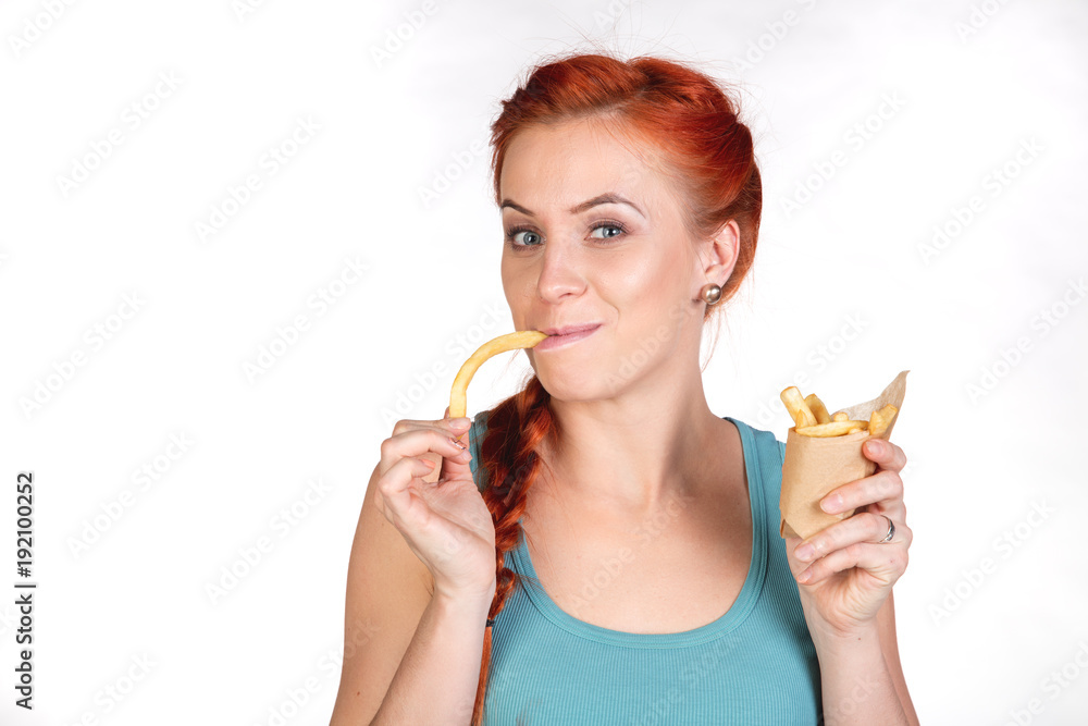 red-haired young woman eating french fries red-haired young woman eating french fries