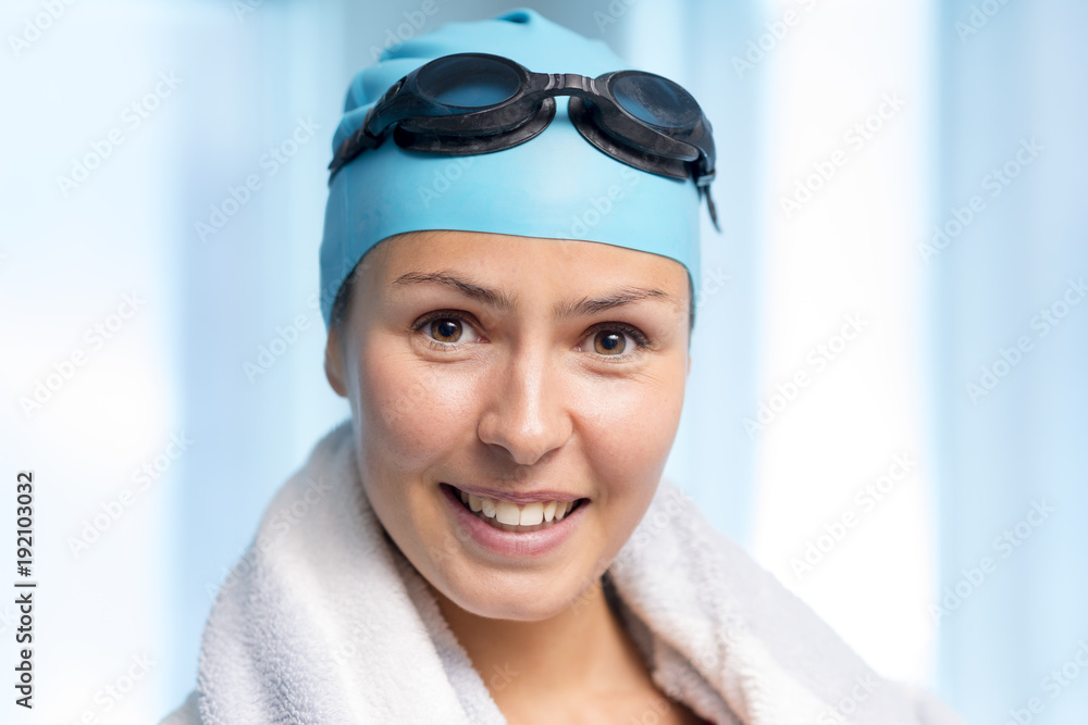 Young Woman Wearing Swimming Cap with Goggles Towel Over Shoulder