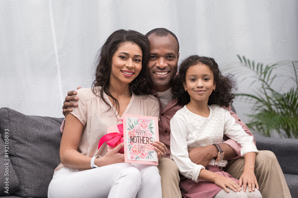 african american parents and daughter looking at camera on mothers day african american parents and daughter looking at camera on mothers day
