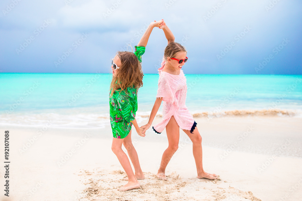 Naklejka premium Kids having fun at tropical beach during tropical summer vacation playing together at beach