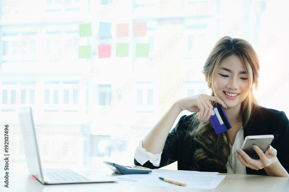 Young asian woman paying with credit card on smart phone at home office, Online payment concept. Young asian woman paying with credit card on smart phone at home office, Online payment concept.