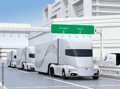 A fleet of self-driving electric semi trucks driving on highway. 3D rendering image.
