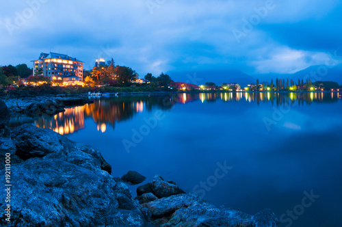 Fuji Five Lake Kawaguchiko Night Ambient surrounded by Rock Water and Building with Blue Cloudy Sky Background Japan Winter  © Naddhawud