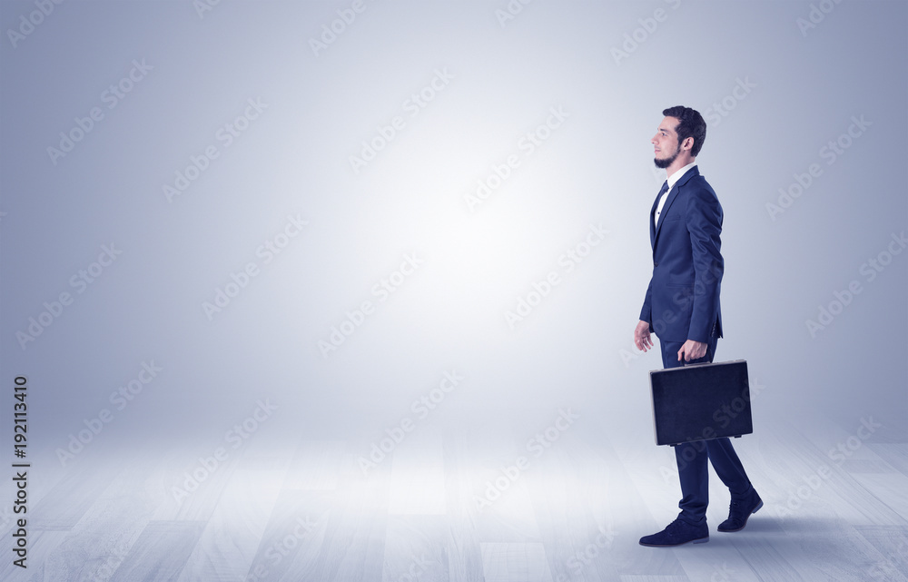 Businessman walking in front of an empty wall Businessman walking in front of an empty wall