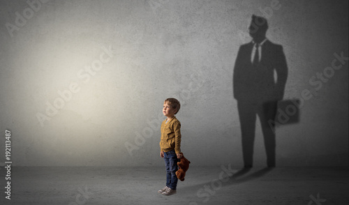 Fotografia Little boy with businessman shadow