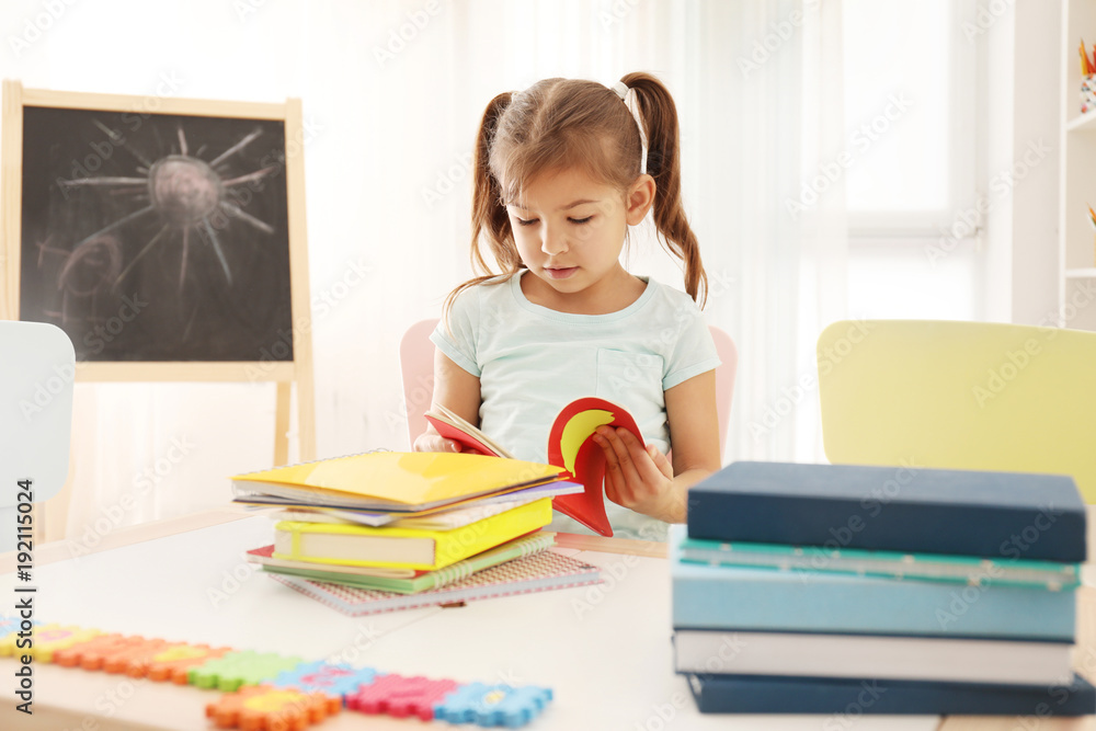 Cute little girl doing homework indoors Cute little girl doing homework indoors