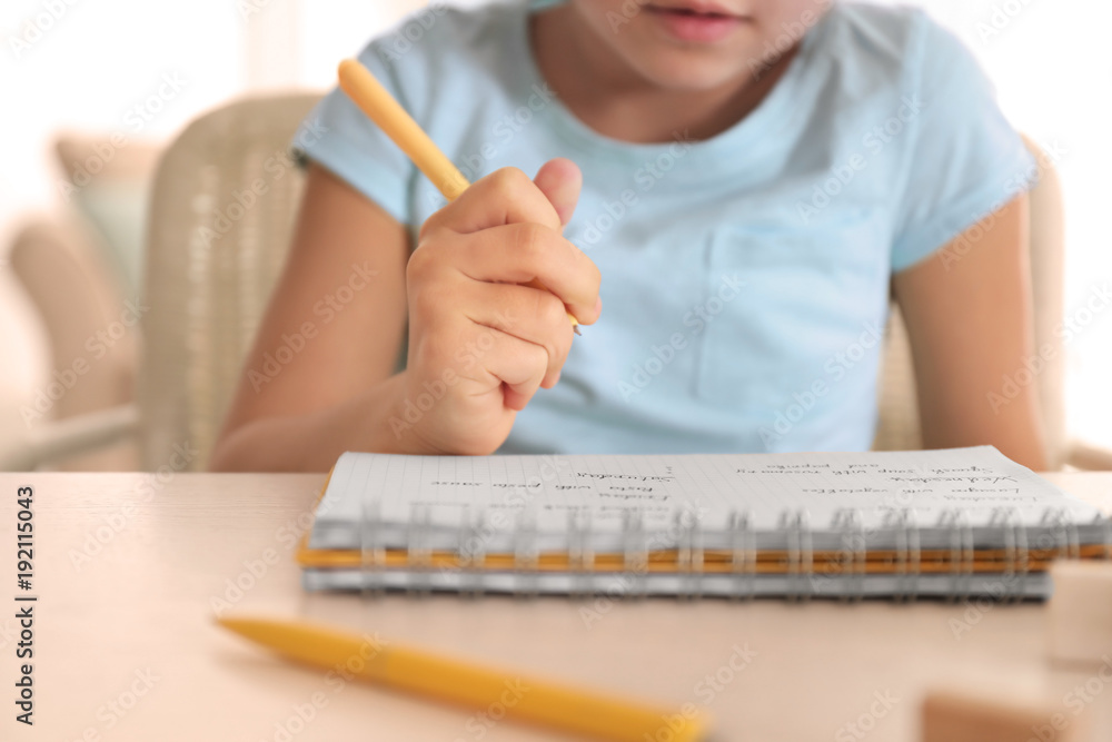 Little girl doing homework indoors, closeup Little girl doing homework indoors, closeup