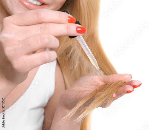 Young woman applying oil on...