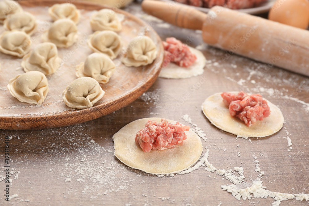 Preparation of dumplings with meat on table, closeup Preparation of dumplings with meat on table, closeup