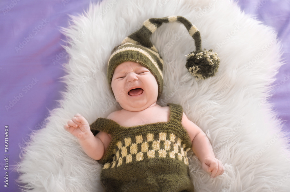 Cute little baby in elf costume lying on fur, top view Cute little baby in elf costume lying on fur, top view