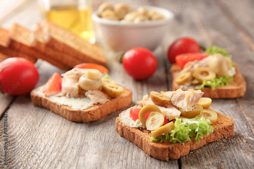 Tasty chicken bruschettas on wooden table Tasty chicken bruschettas on wooden table