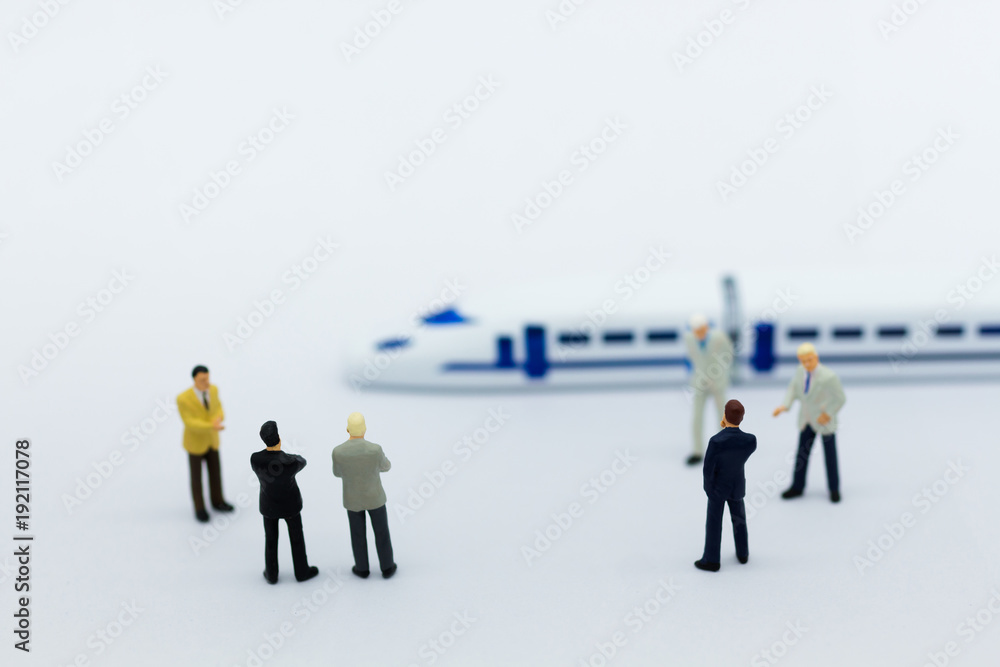 Miniature people: Businessman planning on a project for a train for traveling. Image use for transportation, business concept. Miniature people: Businessman planning on a project for a train for traveling. Image use for transportation, business concept.