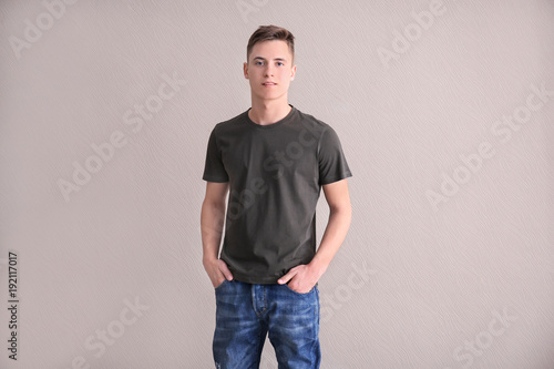 Young man in color t-shirt on light background. Mockup for design © Africa Studio