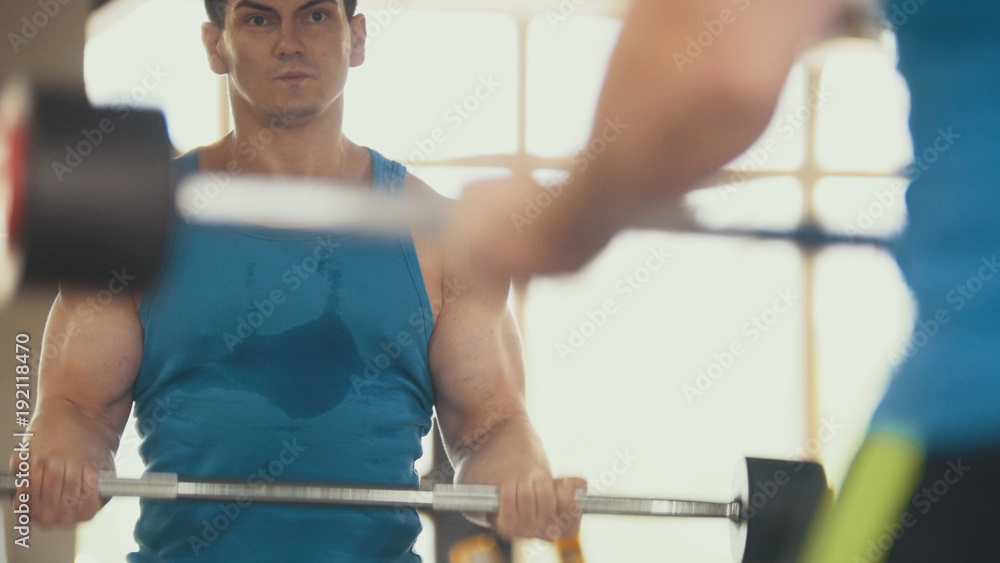 Bodybuilding in the gym - muscular man training his biceps near mirror Bodybuilding in the gym - muscular man training his biceps near mirror