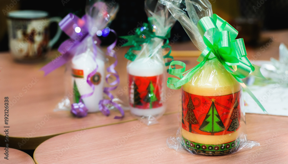 Christmas candles packed with colorful ribbons on a table