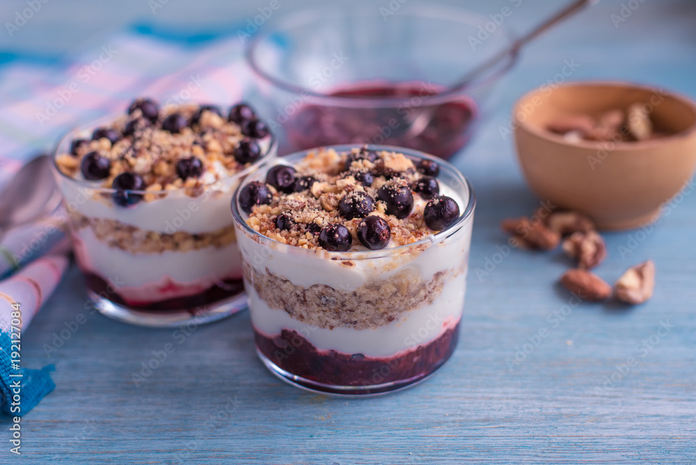 Delicious dessert - yogurt parfait with jam, nuts and currants in a glass Delicious dessert - yogurt parfait with jam, nuts and currants in a glass