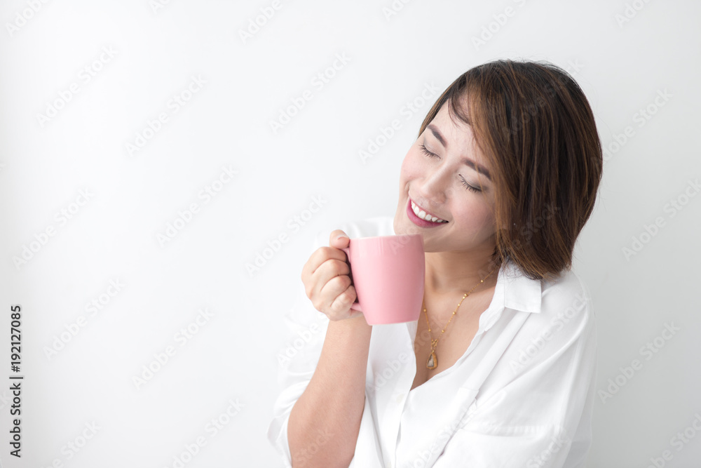 Beautiful woman holding pink cup near window at home. Beautiful woman holding pink cup near window at home.