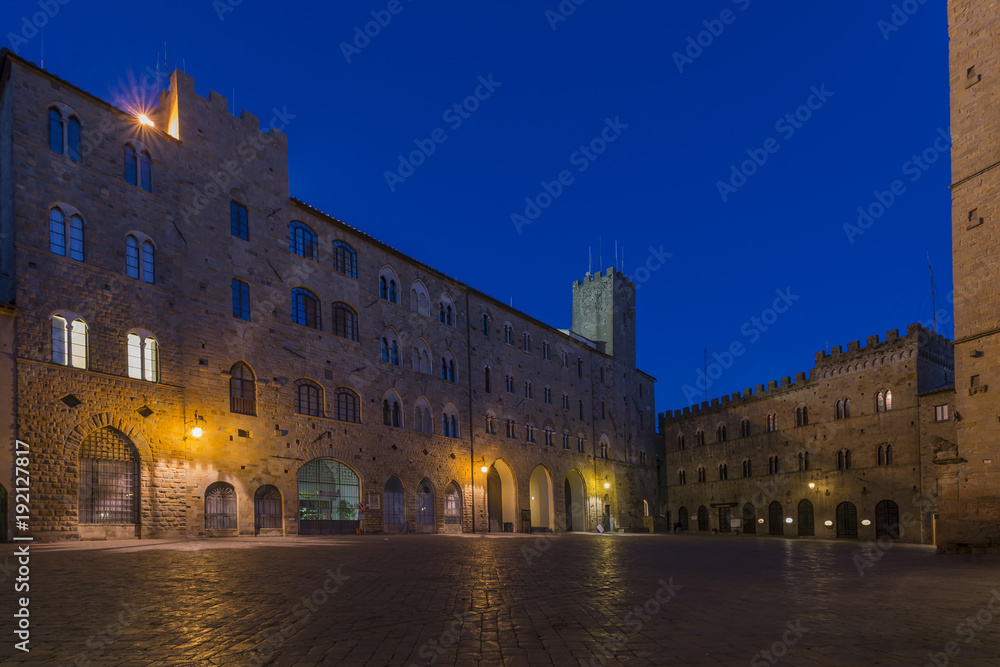 Pretorio Palace and Porcellino Tower, Priori Square in a quiet moment of the evening in the blue light, Volterra, Pisa, Tuscany, Italy