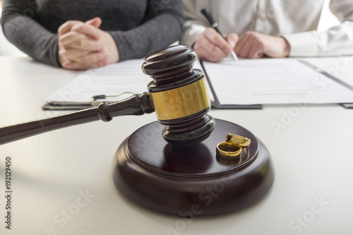 фотографія Hands of wife, husband signing decree of divorce, dissolution, canceling marriage, legal separation documents, filing divorce papers or premarital agreement prepared by lawyer