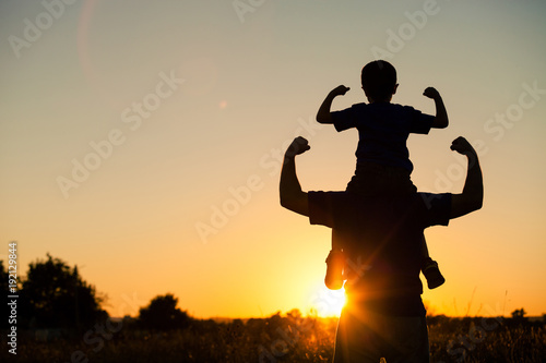 Father and son playing in the park at the sunset time. photo