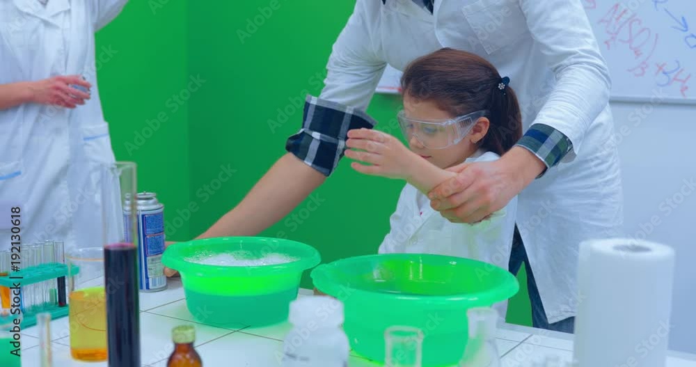 Teacher and students doing science experiment in school classroom. Teacher showing experiment how fire burning on their hands Teacher and students doing science experiment in school classroom. Teacher showing experiment how fire burning on their hands