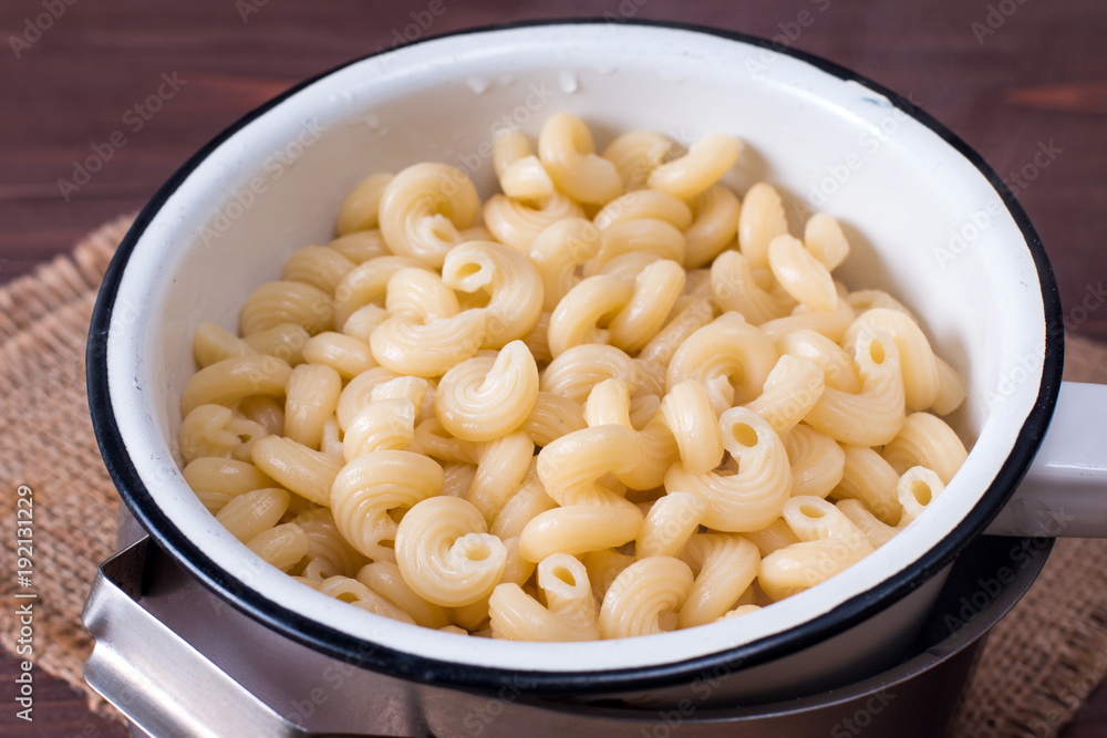 Fresh cooked Pasta in a sieve on a wooden table Fresh cooked Pasta in a sieve on a wooden table