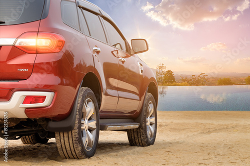 Rear-wheel drive SUV red cars mountains and sky background.