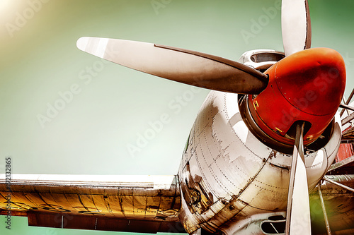 Closeup of an old airplane turboprop engine with propeller blades, parts of wings and aircraft fuselage - historic vintage plane in dramatic look retro style