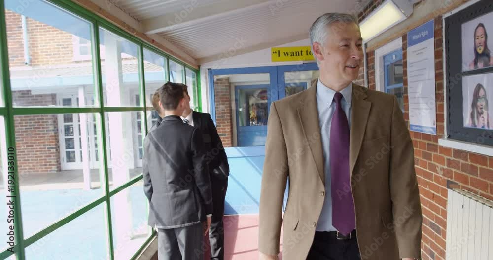 4K Friendly teacher walking through school building & greeting pupils in the hallway. Slow motion 4K Friendly teacher walking through school building & greeting pupils in the hallway. Slow motion