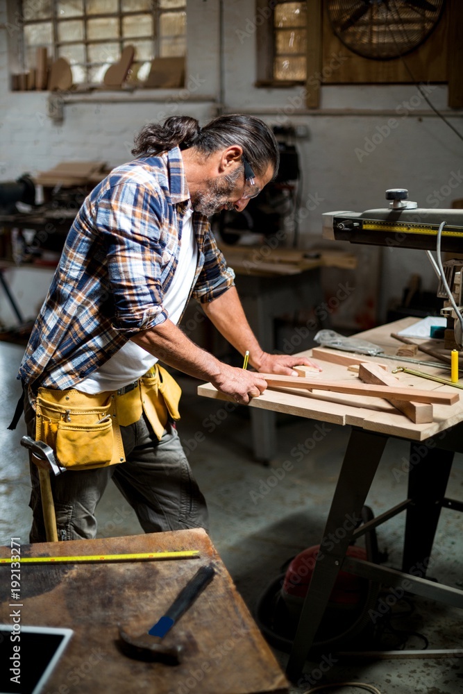 Carpenter marking on wooden plank with pencil Carpenter marking on wooden plank with pencil